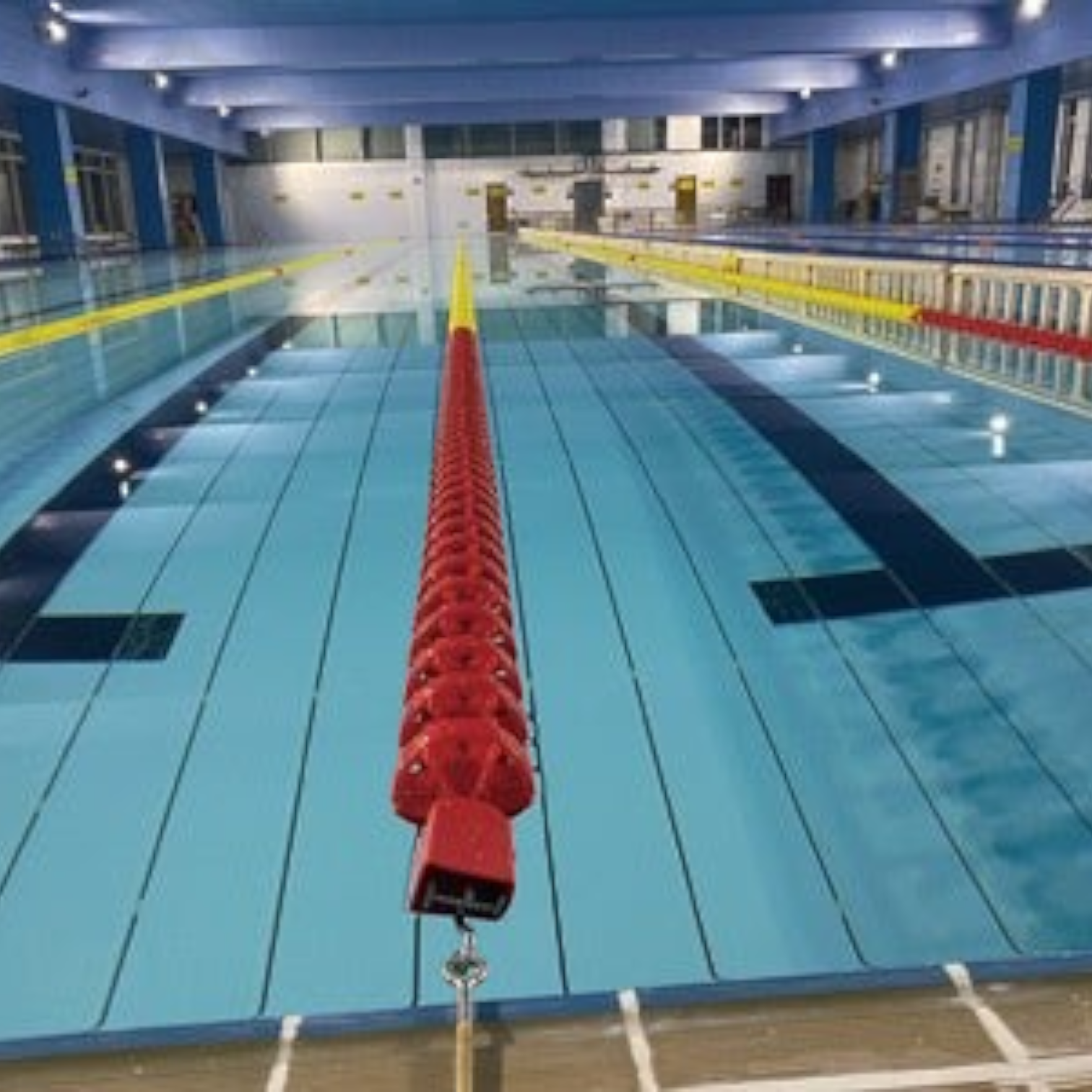 Tali Sport swimming pool lane divider with red and yellow polyethylene floats installed in an indoor pool-8/12 