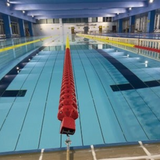 Tali Sport swimming pool lane divider with red and yellow polyethylene floats installed in an indoor pool 