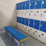 Tali Sport blue and yellow plastic locker room bench in front of blue and white storage lockers 