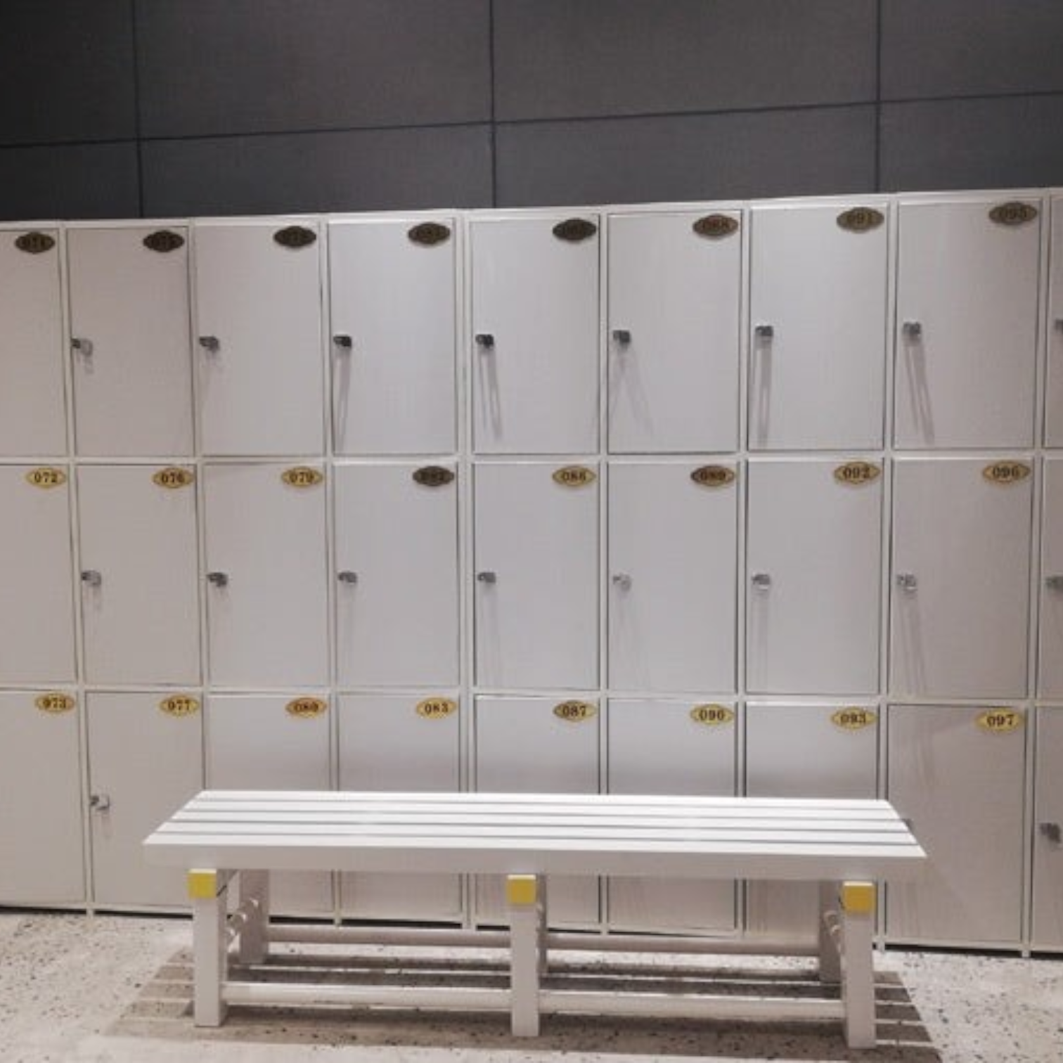 Tali Sport white plastic changing room bench in front of a wall of lockers for gyms and swimming pools-6/7 