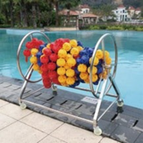 Tali Sport swimming pool lane rope with colorful hexagonal floats on a stainless steel storage reel by the pool 