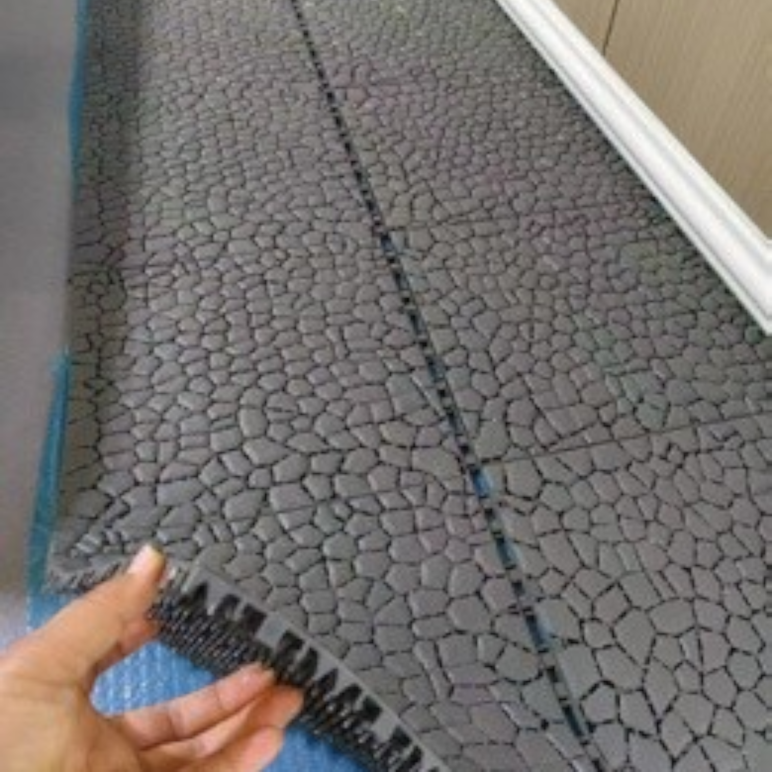 Tali Sport grey modular non-slip PVC pool mat with a textured pebble design for showers and changing rooms-12/14 